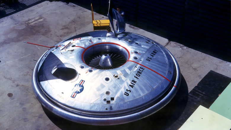 The Avrocar shown from above, a frisbee-shaped flying saucer stamped with US military labels