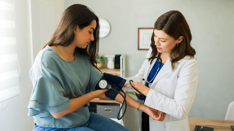 Woman getting her blood pressure checked by a doctor