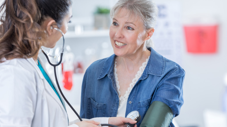 Doctor talking with a patient while taking their blood pressure
