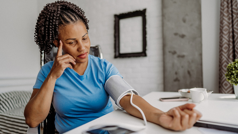 Woman measuring her own blood pressure at home