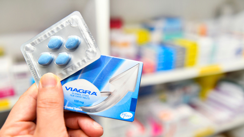Hand holding a package of Viagra in a pharmacy