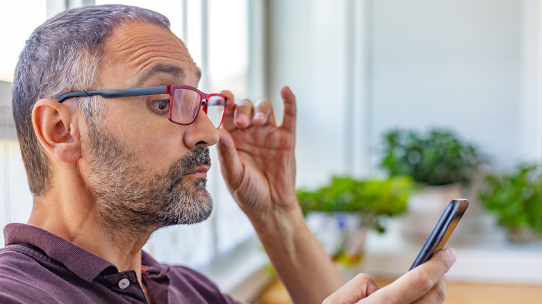 Man experiencing vision issues while looking at phone