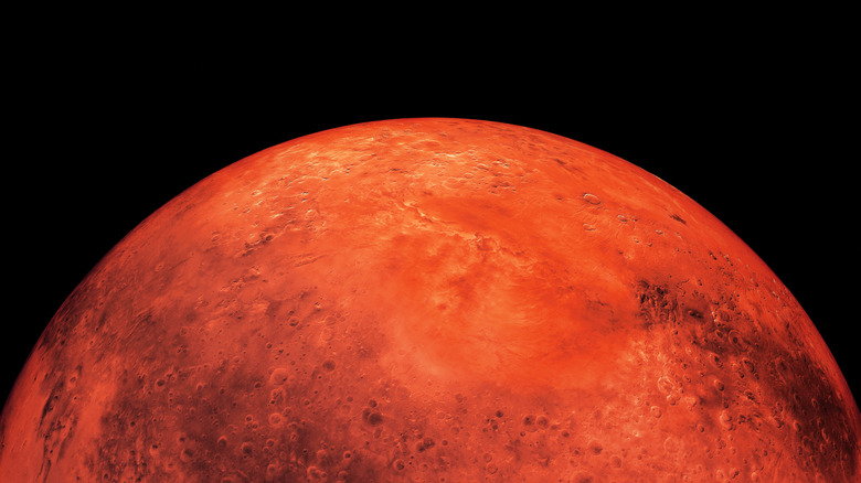 Planet Mars is red against a dark backdrop