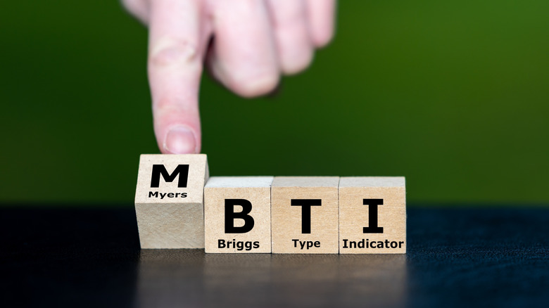 Someone placing blocks that spell out MBTI.