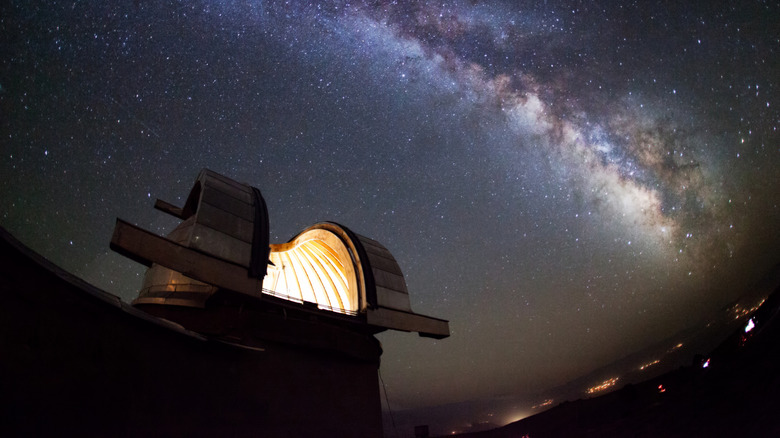 An observatory with open dome under a starry sky