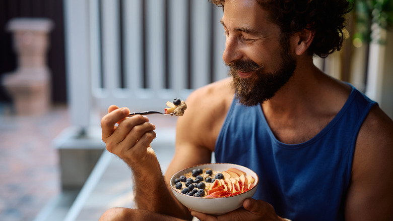 Man eating oatmeal with fruit after a workout