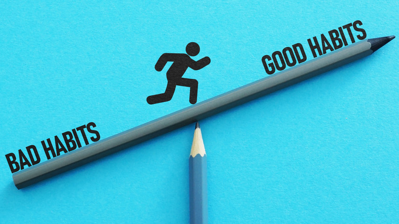 A pencil balancing on another pencil with a person's silhouette in the center running from 