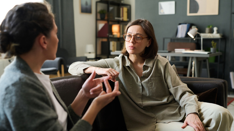 Two women sitting on a sofa having a conversation