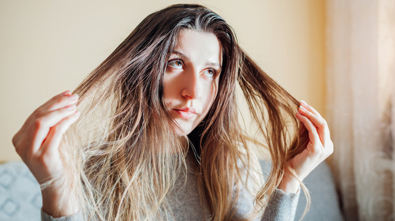 Woman holding strands of hair on both sides of her head