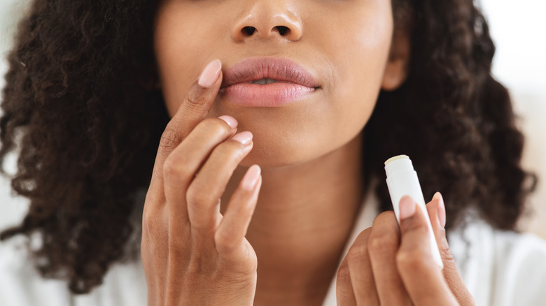 Woman applying lip balm