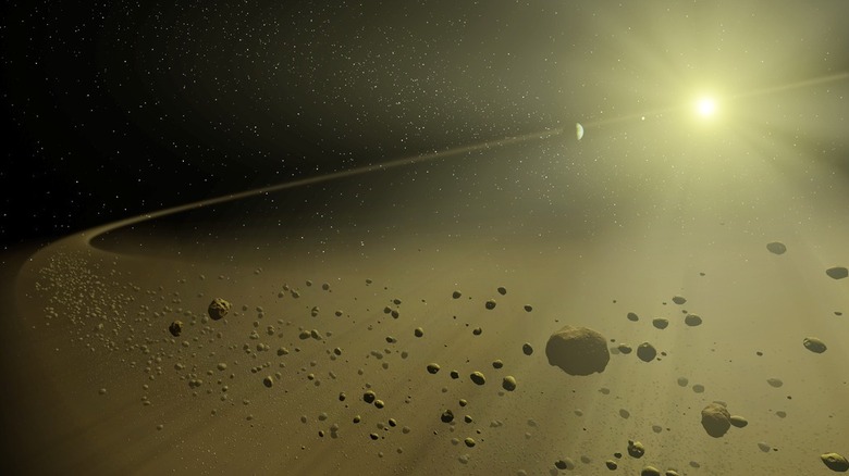 Artist's concept of a star system forming with a bright star surrounded by dust clouds and rocky debris