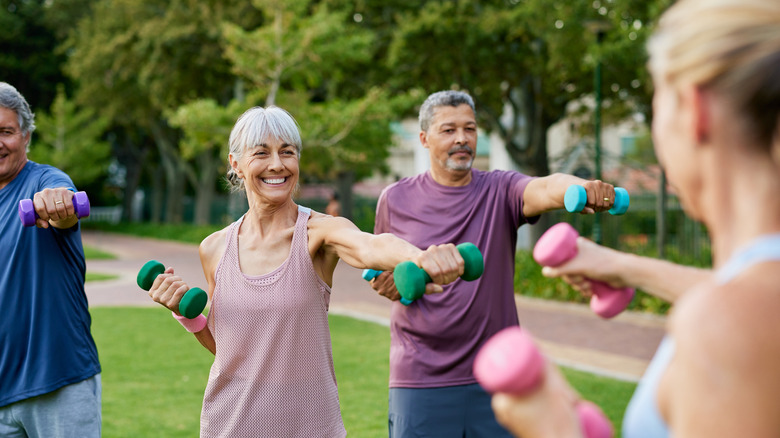A group of older adults in an outdoor weight-lifting class
