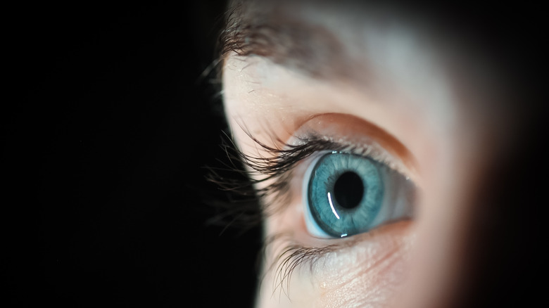 Closeup of blue eye in dark