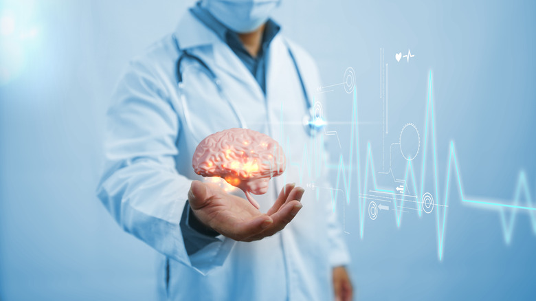 Male doctor extending hand with CGI brain floating in his palm