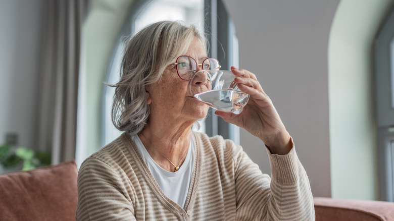 Older woman drinking glass of water