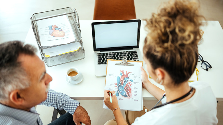 Doctor discussing a diagram of the heart with a patient