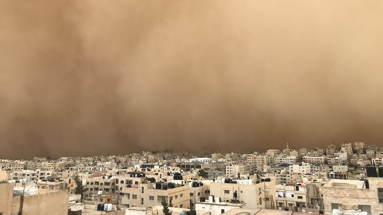 A sandstorm sits on the horizon over a city