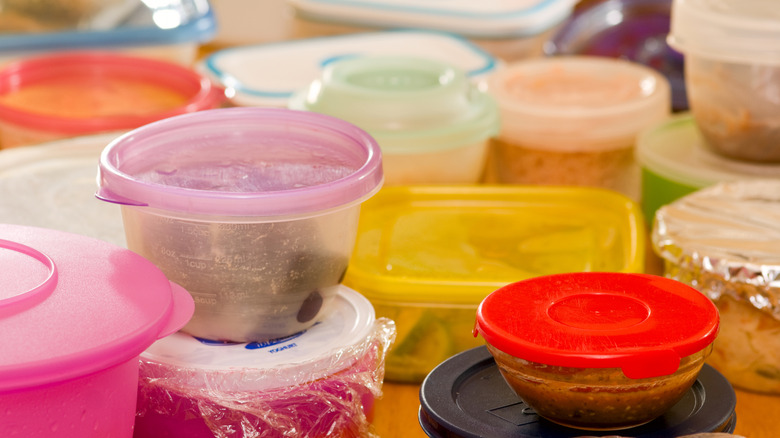 Several multicolored plastic containers filled with leftovers