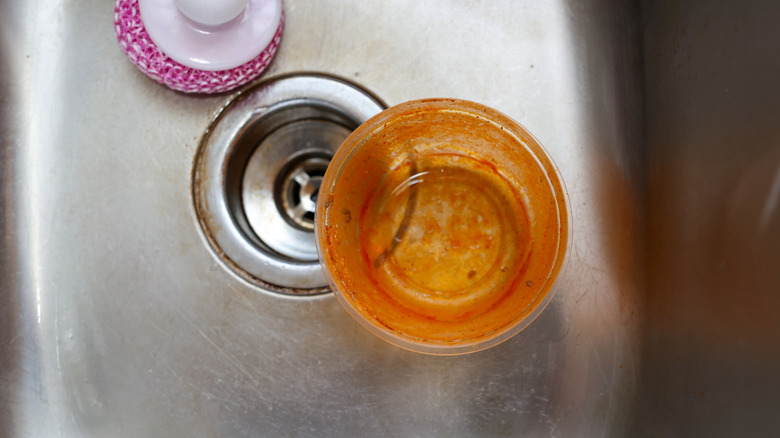 Old, stained plastic food container in a sink
