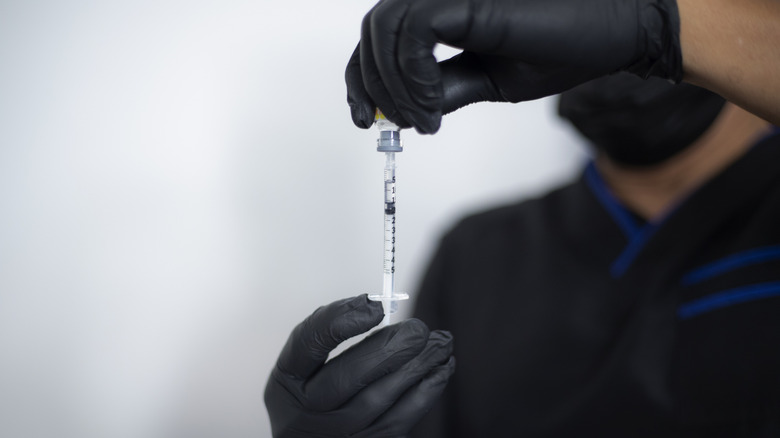 Health care provider filling syringe with Botox