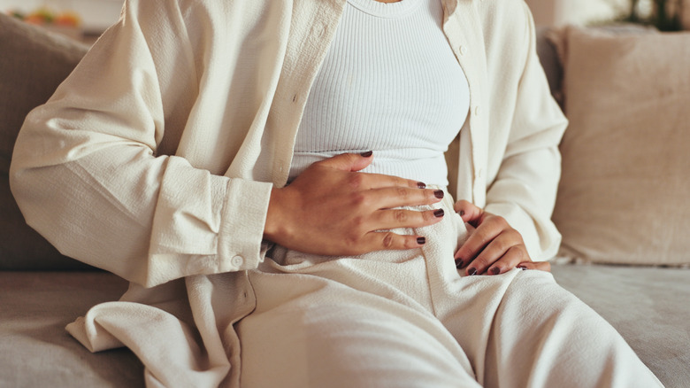 Woman holding her stomach as if in pain