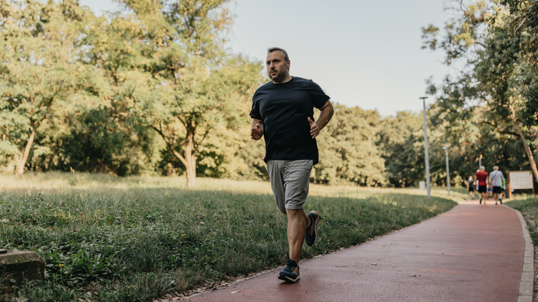 Middle-aged, overweight man jogging in a park