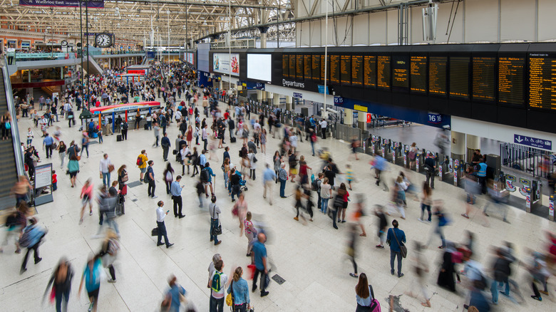 Crowds of people walking around a busy train station