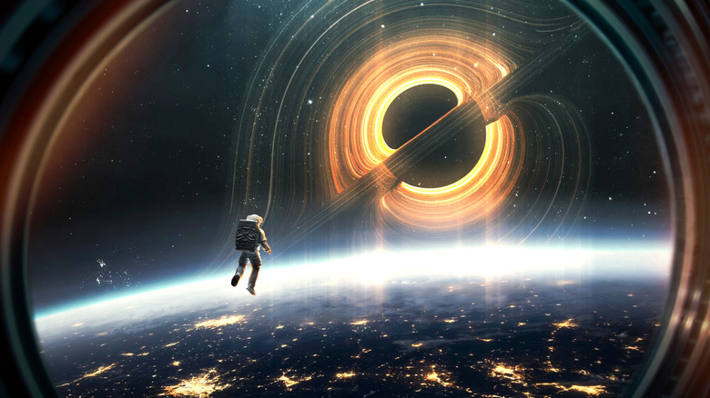 Free-floating astronaut in space above the earth with black hole in distance