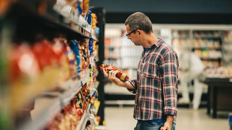 A man looking at a food label at a supermarket