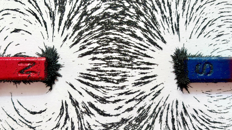 Magnetic field attracting iron filings between two magnets
