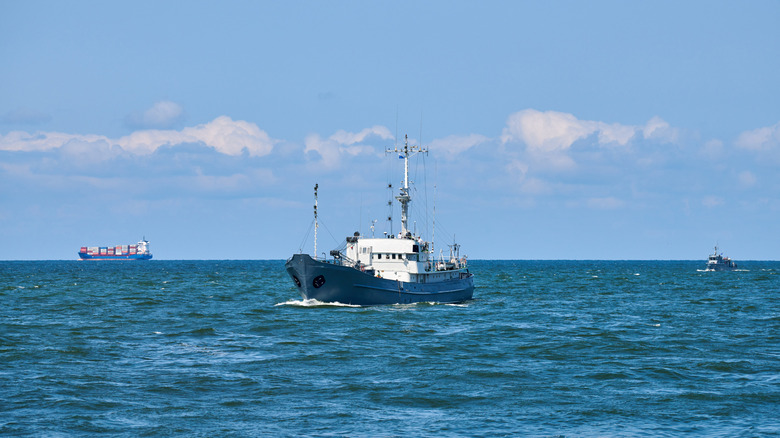 A navy research vessel, medium-sized ship in white and blue colors floating on ocean surface