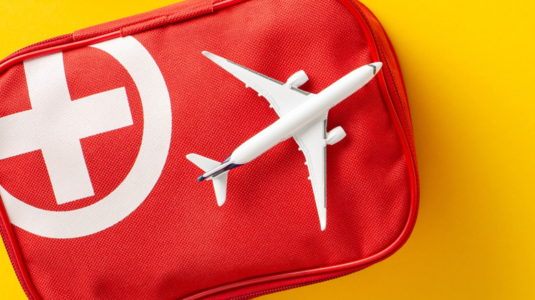 White toy plane on a red medical bag featuring the white medical cross