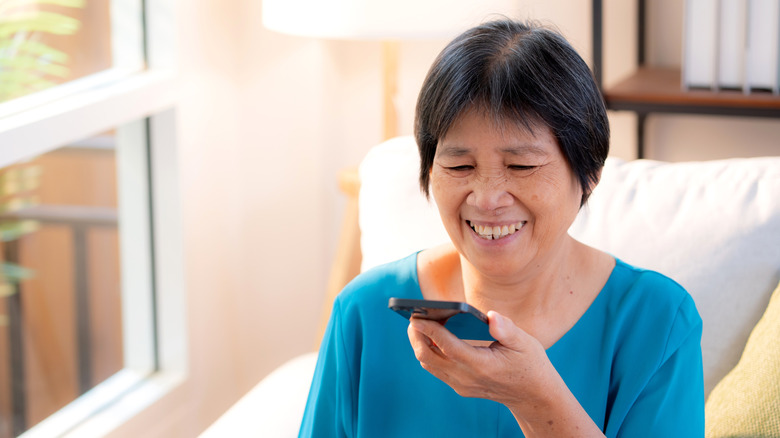 Woman speaking into her phone, making a voice note