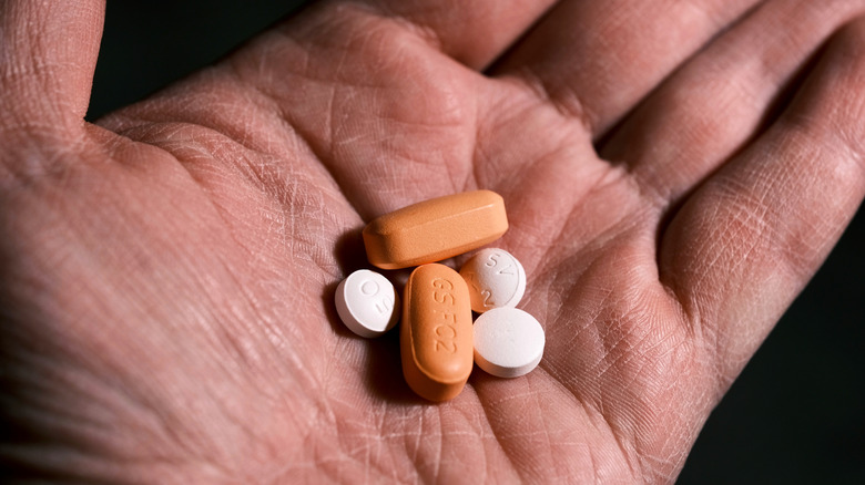 Multiple pills held in a person's hand