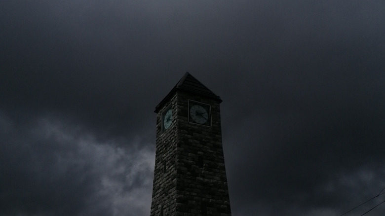 A clock tower with dark storm clouds brewing behind it.