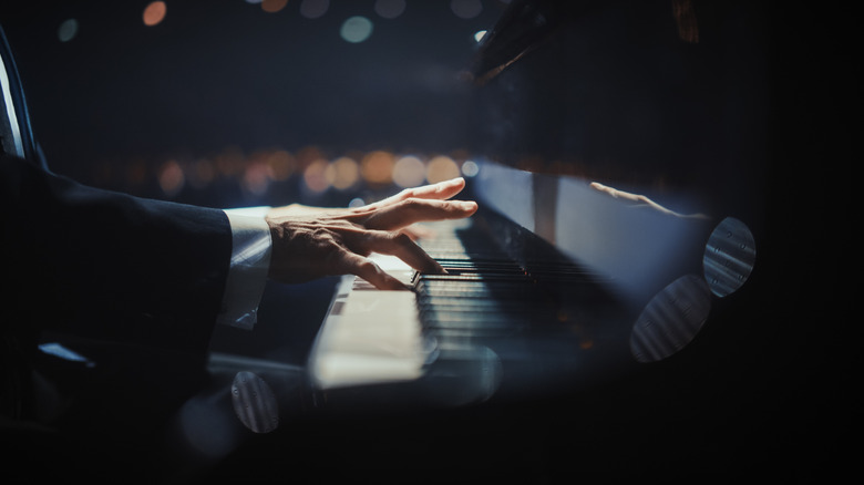 A close-up of a hand playing a piano.