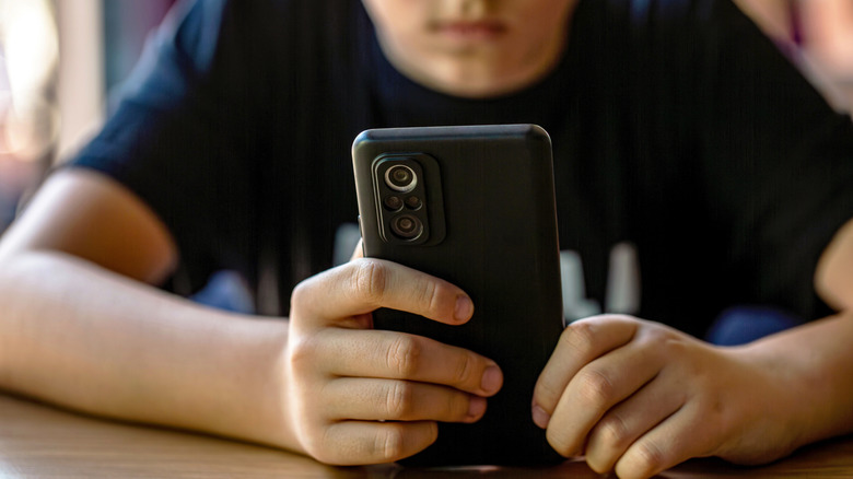 A child holding a smartphone.