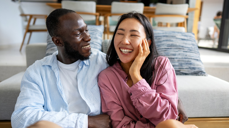 Happy couple laughing together on the couch