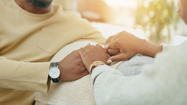 Closeup detail of couple holding hands