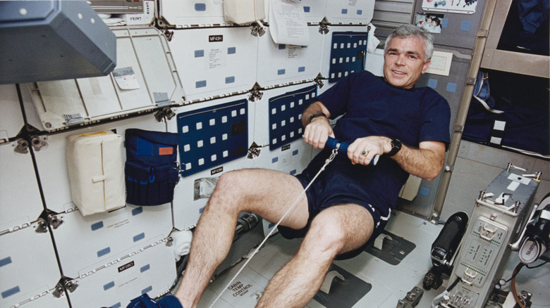 NASA astronaut exercising with a rowing machine during a space shuttle mission