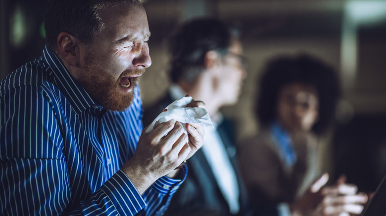 Man about to sneeze into a hankerchief