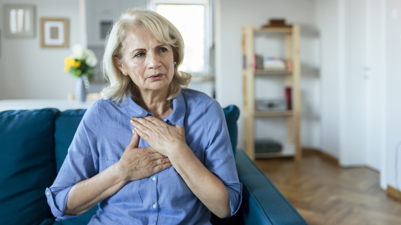 Woman holding her chest and looking worried