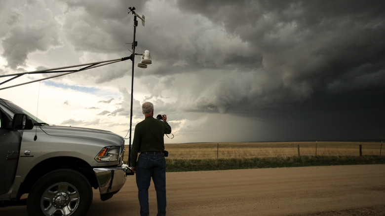 Man standing beside next to a storm chaser vehicle