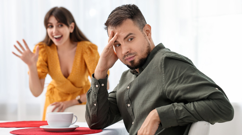 A man is ignoring a woman's body language