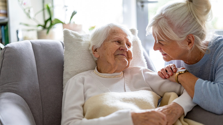 Elderly woman  and caregiver smiling at each other