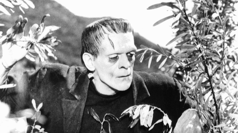 Boris Karloff's Frankenstein's Monster peeking through bushes in Frankenstein