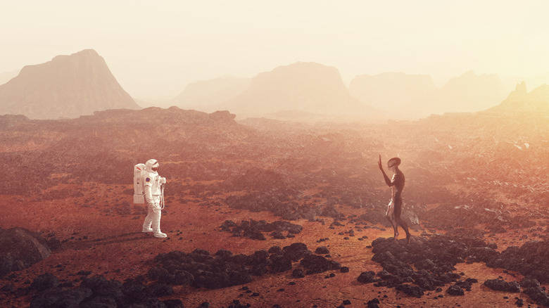 An astronaut is meeting an alien