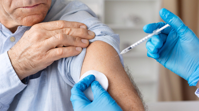 A man receiving a vaccine injection from a health care professional