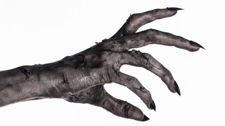 Long fingernails on a "dead" hand in the style of a horror movie