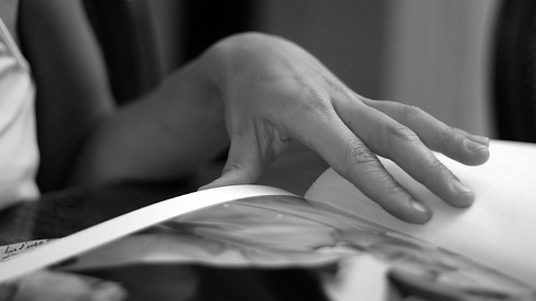 A woman's hand resting on a photo album.